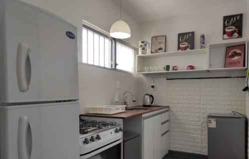 a white kitchen with a stove and a refrigerator at Casa playa hermosa frente al mar in Playa Hermosa