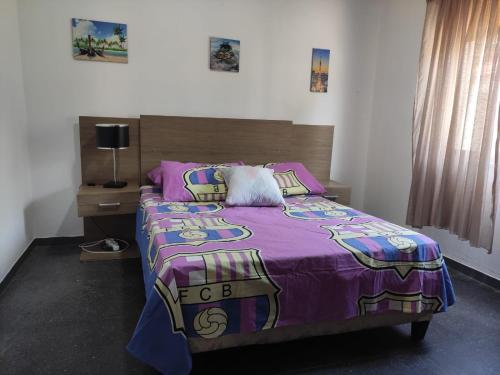 a bedroom with a bed with a purple comforter at Casa playa hermosa frente al mar in Playa Hermosa