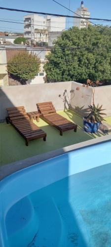 two lounge chairs and a swimming pool on a roof at Hotel dyd in Necochea