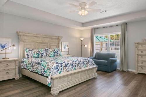 a bedroom with a bed and a chair and a window at Happy Ours in Foley