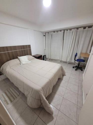 a bedroom with a bed and a chair in it at Monoambiente en plena Ciudad de Mendoza in Mendoza