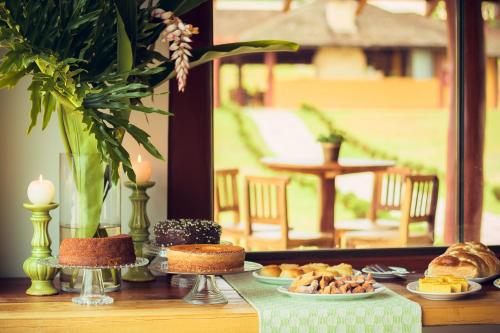 a table topped with plates of food and candles at Pousada Boyrá in Bonito