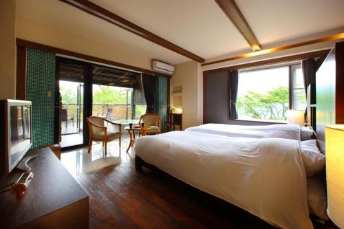 a hotel room with a bed and a table and chairs at Hakone Fontaine Bleau Sengokutei in Hakone