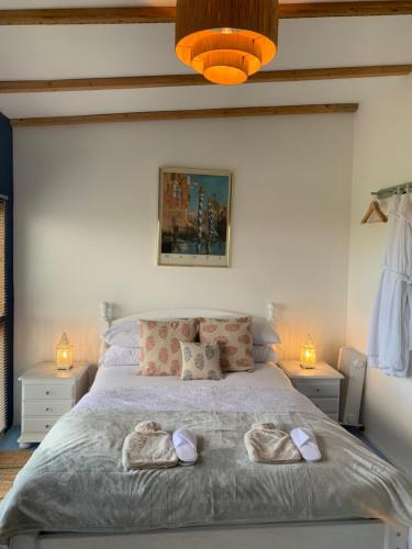 una camera da letto con un letto e due asciugamani di Countryside Garden Summer House a Calne