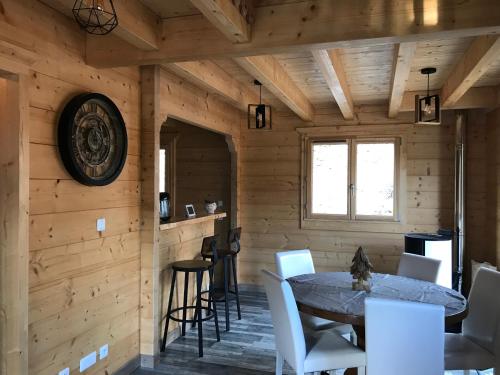 - une salle à manger dans une cabane en rondins avec une table et des chaises dans l'établissement Forest Jura Lodge - Chalet des sapins, à Alièze
