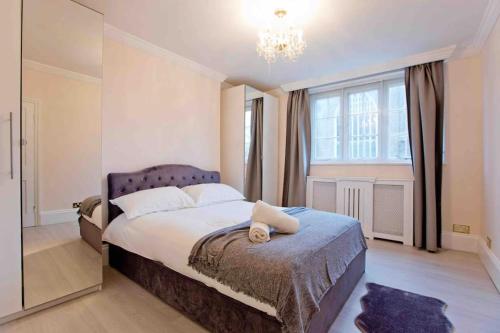 a bedroom with a bed and a large window at Beautiful 4 Bed House by Regents Park in London