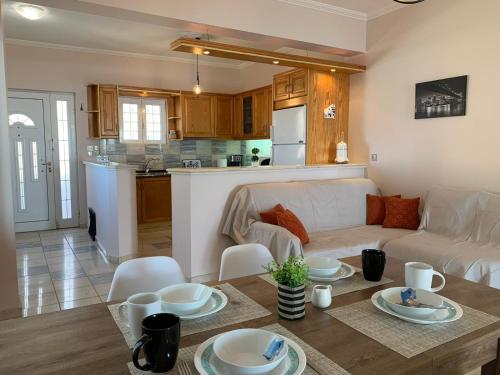 uma sala de estar e cozinha com um sofá e uma mesa em VillAri Lefkas Suites em Exanthia