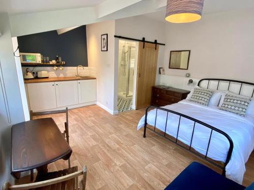 Long BurtonにあるThe Snug at Caphays: perfect rural retreatのベッドルーム1室(ベッド1台、テーブル付)、キッチン