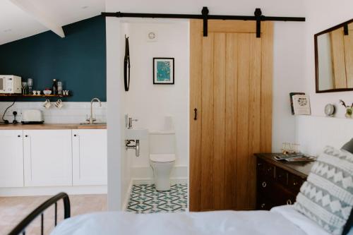 uma casa de banho com um lavatório e um WC num quarto em The Snug at Caphays: perfect rural retreat em Long Burton