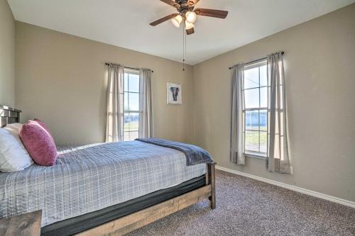 - une chambre avec un lit, un ventilateur de plafond et des fenêtres dans l'établissement Peaceful Atascosa Home with Balcony and Deck!, à Lytle