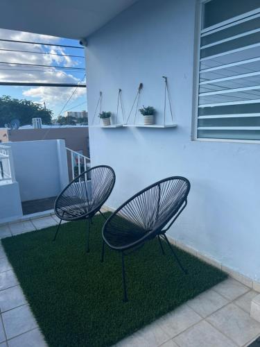 dos sillas sentadas en la parte superior de un parche de hierba en San Juan Home en San Juan