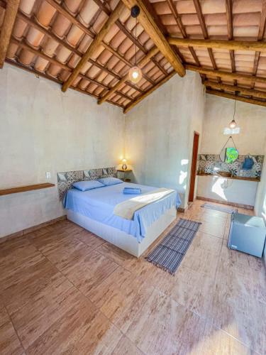 um quarto com uma cama grande e um tecto de madeira em Pousada Flor de Laranjeira em Goiás