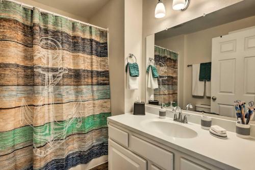 La salle de bains est pourvue d'un lavabo et d'un rideau de douche. dans l'établissement Cozy Delafield Apartment - Walk to Lake!, à Delafield