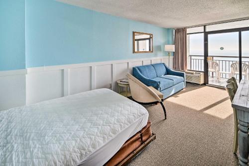 a bedroom with a bed and a chair and a window at Oceanfront Myrtle Beach Condo with Balcony! in Myrtle Beach