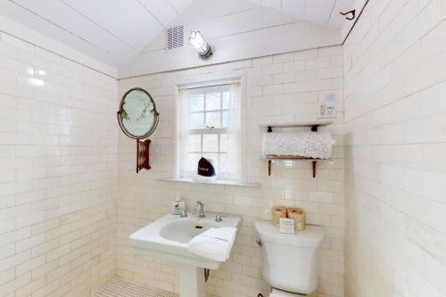 Baño blanco con lavabo y aseo en The Lighthouse, en Provincetown