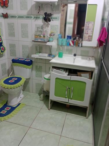 a bathroom with a sink and a toilet and a mirror at Casa da Joci in Bonito