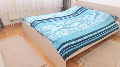 Bett mit blauer Decke auf einem Zimmer in der Unterkunft ELEGANCE Apartment in Sarajevo