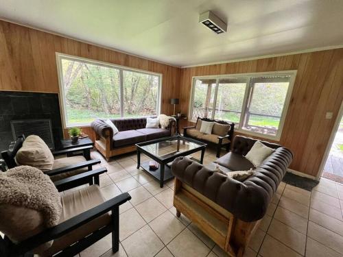 a living room with couches and a fireplace at Cabaña en el bosque de Llanos del Castor in Ushuaia