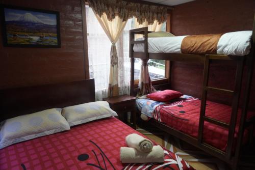 a bedroom with two bunk beds and a window at Playita Salomon in Baños