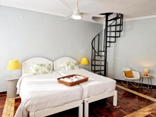 a bedroom with a white bed and a spiral staircase at ASPA - São Paulo Studios in Funchal