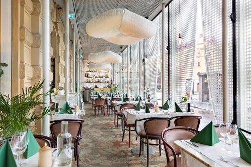 a restaurant with tables and chairs and large windows at Best Western Hotel Baltic in Sundsvall
