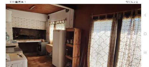 uma cozinha com duas janelas e um frigorífico em cabañas LAS GARZAS 3 em Guazuvirá