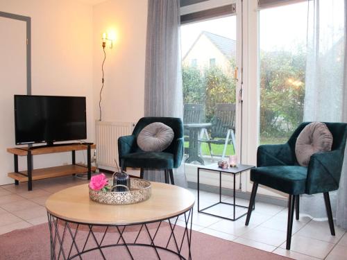 a living room with two chairs and a tv at Nice holiday home with sauna, in a holiday park only 200m away from the beach in Wemeldinge
