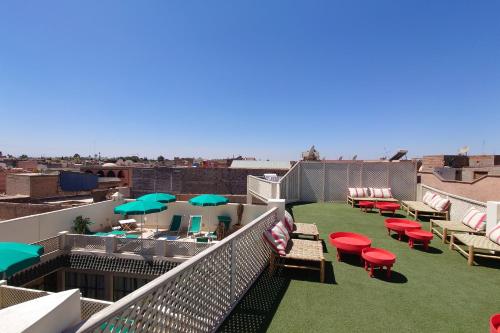 a balcony with chairs and umbrellas on a roof at Miostello Lifestyle Hostel Marrakech in Marrakesh