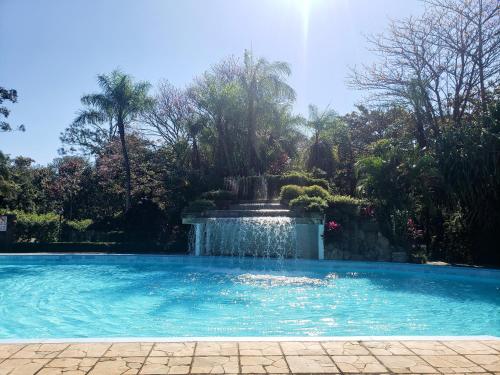 a swimming pool with a fountain in a garden at Casa Vida - Arte, Naturaleza y Confort in Santa Cruz de la Sierra
