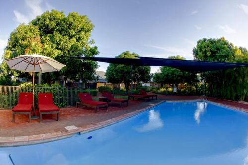 
a patio area with a pool table and chairs at Mantra Frangipani Broome in Broome
