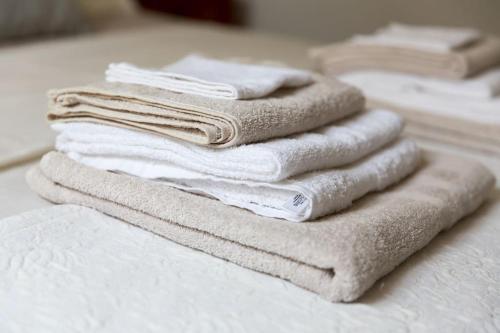 a stack of towels sitting on top of a bed at LHV Garda Lake - Private POOL and SPA in Bardolino