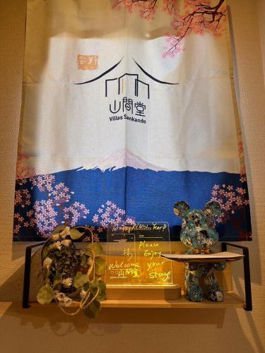 a display case with vases on a table in front of a banner at ヴィラ山間堂Panorama Villa BBQ Bonfire Fuji view Annovillas Sankando in Fujikawaguchiko