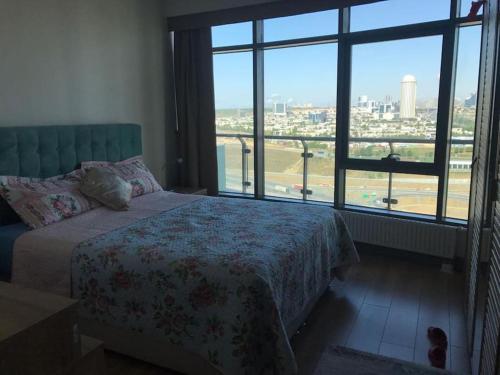 - une chambre avec un lit et une grande fenêtre dans l'établissement mall of istanbul, à Basaksehir