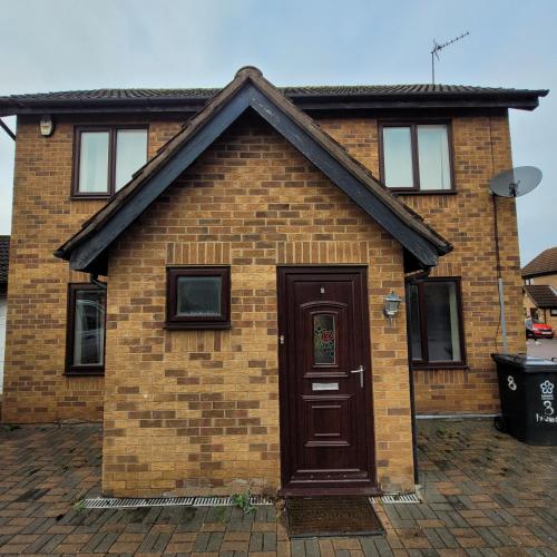 uma casa de tijolos com uma porta castanha em hamilton 3 bedrooms 10 minutes from city centre em Leicester