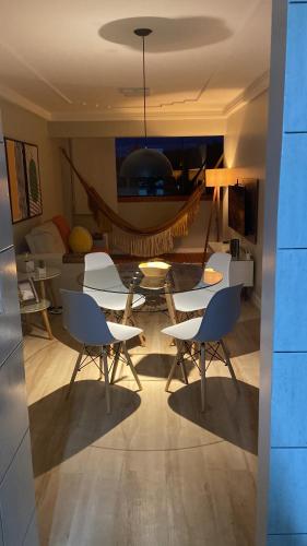 uma sala de estar com uma mesa e cadeiras e um sofá em Ap Cozy Calhau prox PRAIA em São Luís