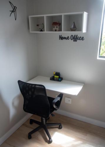 a white desk with a chair and a home office sign at Ap Cozy Calhau prox PRAIA in São Luís