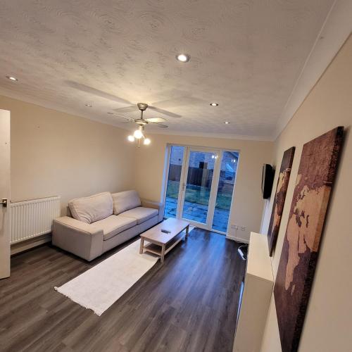 a living room with a couch and a table at hamilton 3 bedrooms 10 minutes from city centre in Leicester