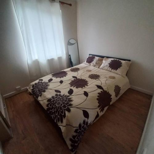 a bedroom with a bed with a flowery comforter at hamilton 3 bedrooms 10 minutes from city centre in Leicester