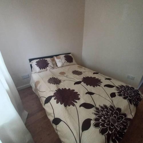 um quarto com uma cama com colcha floral em hamilton 3 bedrooms 10 minutes from city centre em Leicester