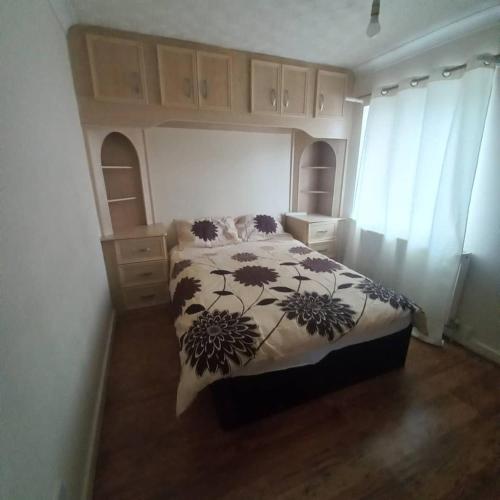 Schlafzimmer mit einem Bett mit einer schwarzen und weißen Bettdecke in der Unterkunft hamilton 3 bedrooms 10 minutes from city centre in Leicester