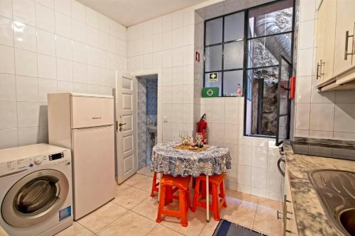a kitchen with a table and a washing machine at Ribeira Smart Flat in Porto