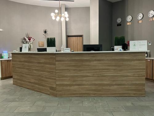 a lobby with a large wooden counter with clocks at Wyndham Garden North Bergen - Secaucus in North Bergen