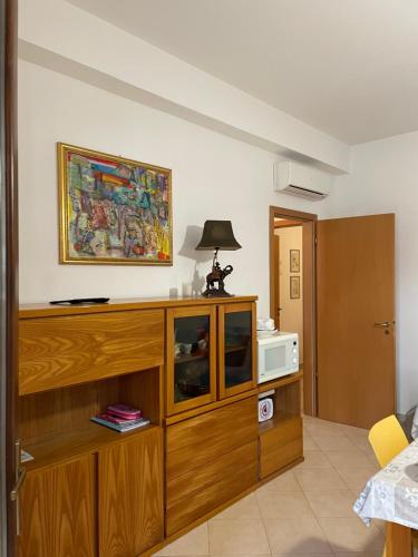 ein Wohnzimmer mit einem großen Unterhaltungszentrum aus Holz in der Unterkunft Belmare trilocale a piano terra indipendente in San Vito lo Capo