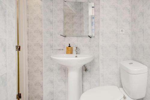 a white bathroom with a sink and a toilet at Ribeira Smart Flat in Porto