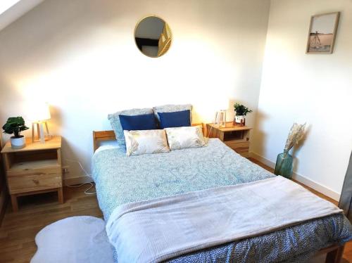 - une chambre dotée d'un lit avec des draps bleus et un miroir dans l'établissement Paisible duplex au centre-ville, au Mans