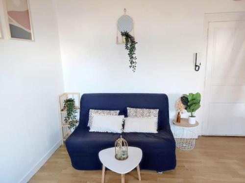 - un canapé bleu dans le salon avec une table dans l'établissement Paisible duplex au centre-ville, au Mans