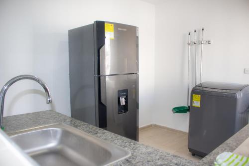um frigorífico de aço inoxidável numa cozinha com um lavatório em APARTAMENTO VALLEDUPAR em Valledupar
