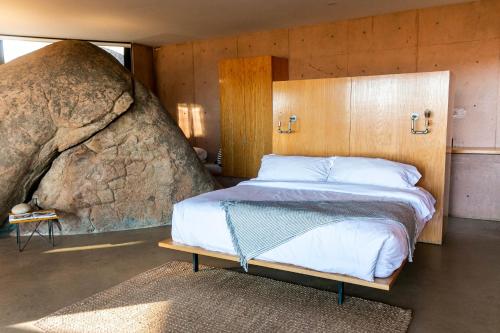 a bedroom with a bed in front of a large rock at Villa Garven in Valle de Guadalupe