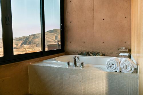 La salle de bains est pourvue d'une baignoire et offre une vue sur la montagne. dans l'établissement Villa Garven, à Valle de Guadalupe