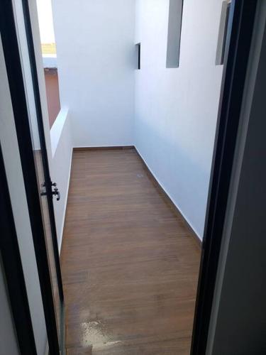a hallway with a wooden floor and an open door at Departamento Siete Loft Sábalo in Mazatlán